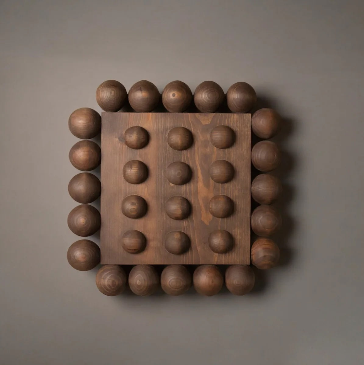 Wooden wall art with spherical protrusions on a brown background