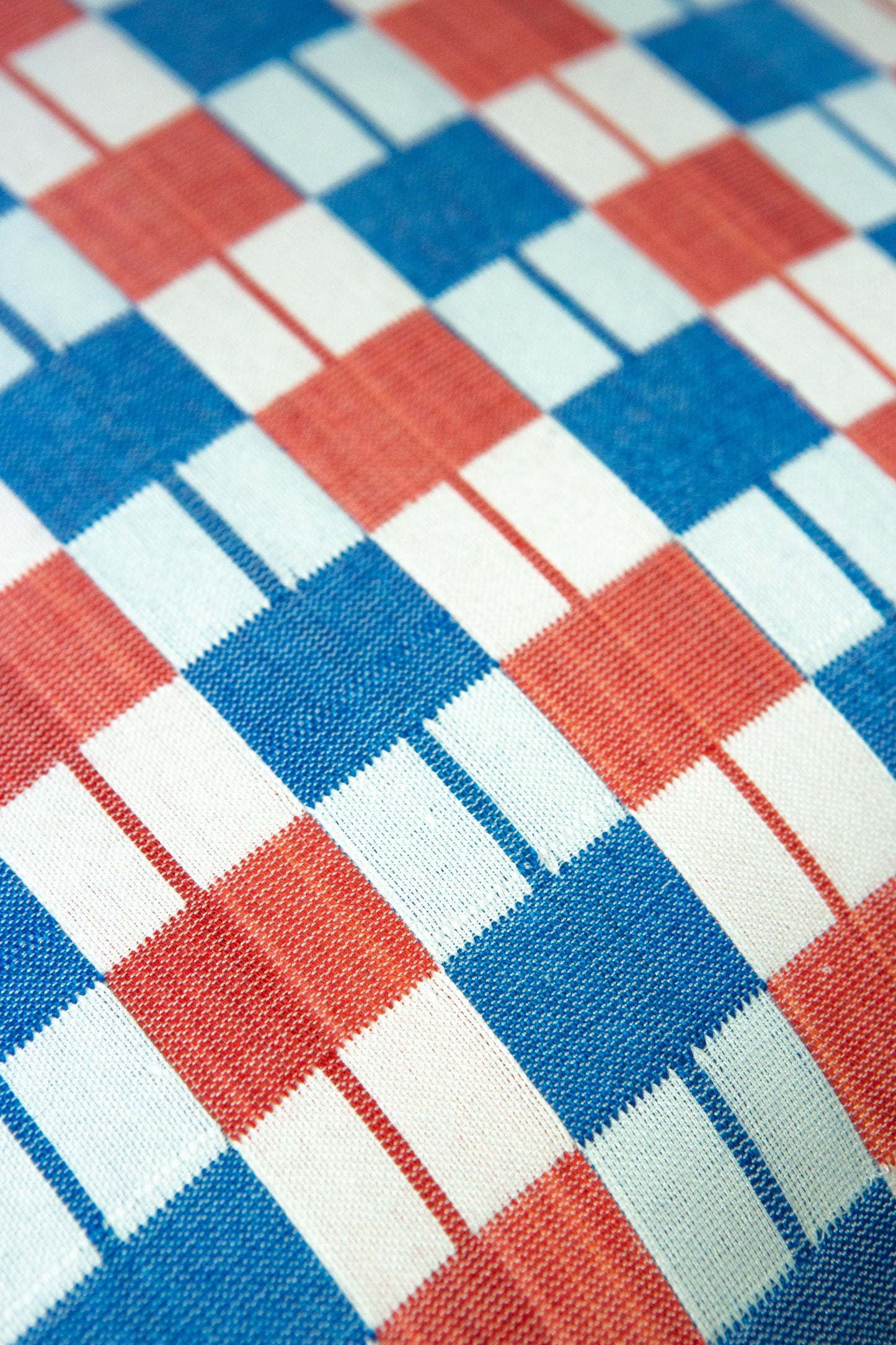 Close-up of a checkered fabric pattern with red, blue, and white squares.