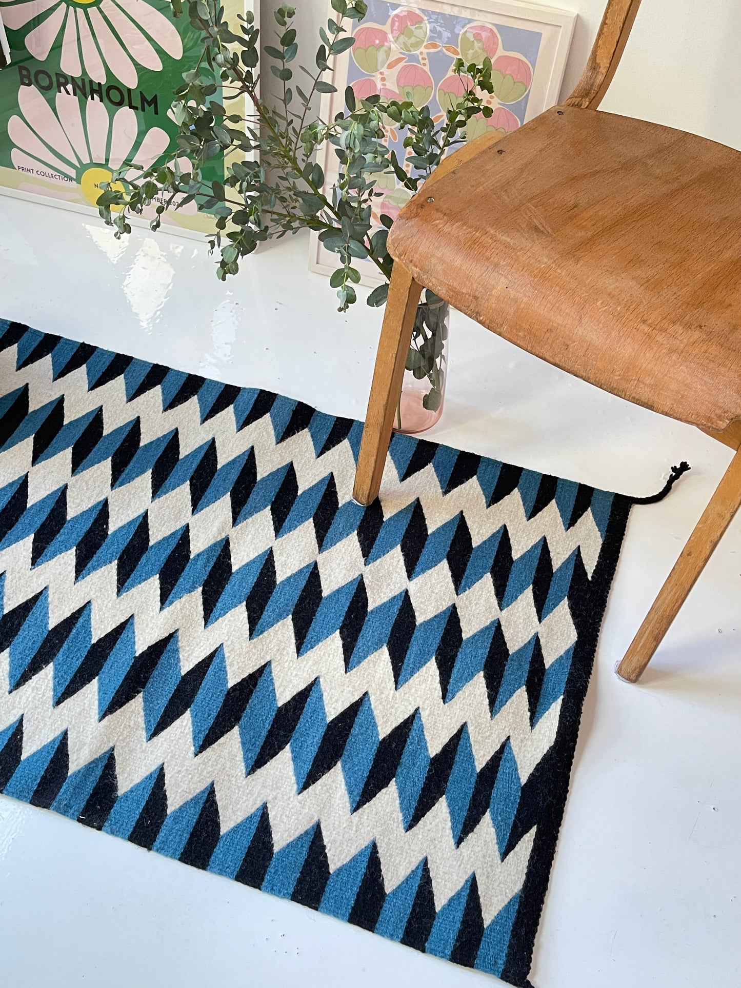 Geometric patterned rug with a chair on a white floor