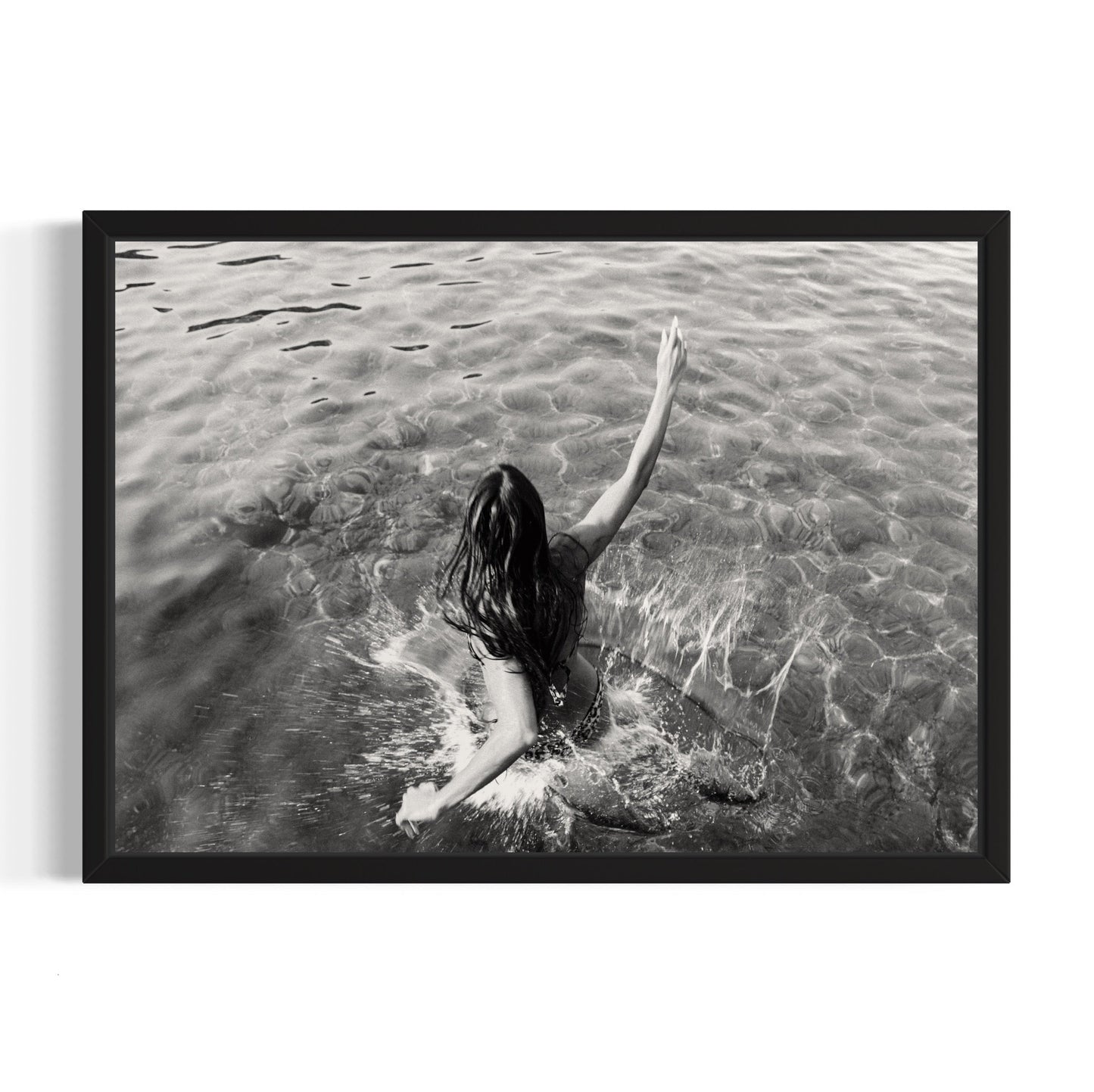 Black and white framed artwork of a person in water with one arm raised.
