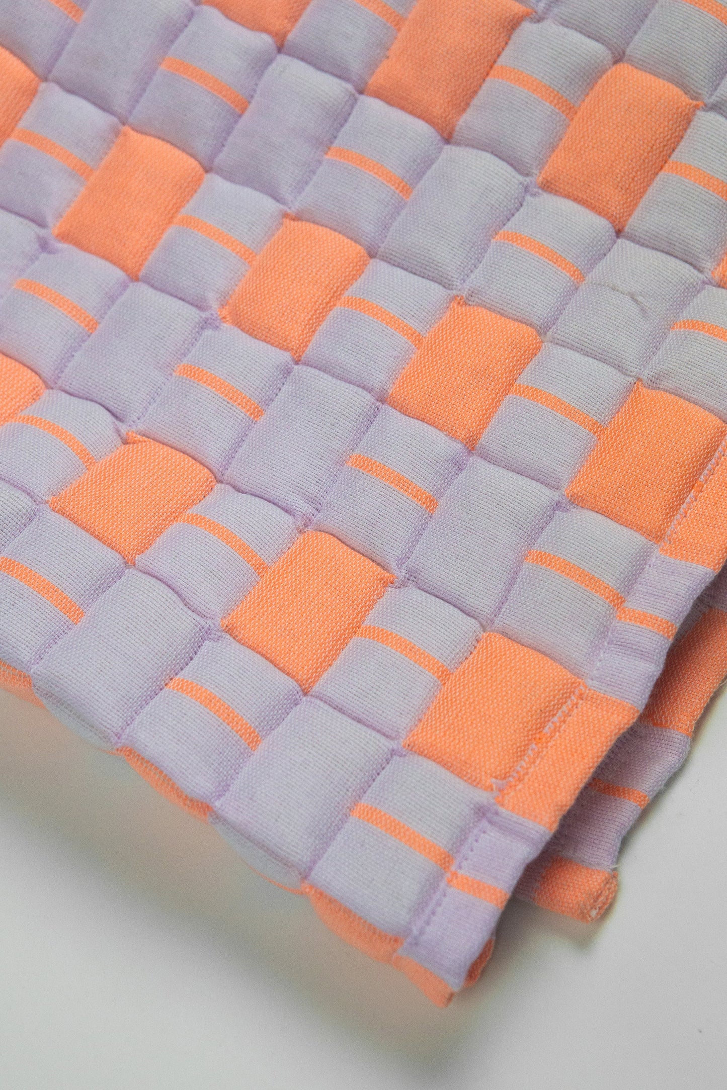 Quilt with orange and gray diamond pattern on a white background