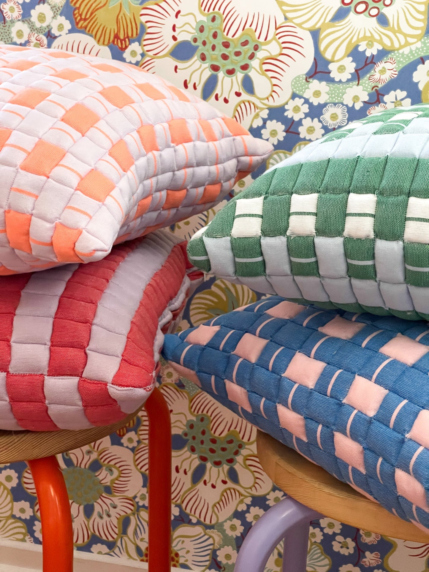 Colorful woven cushions on a floral-patterned background