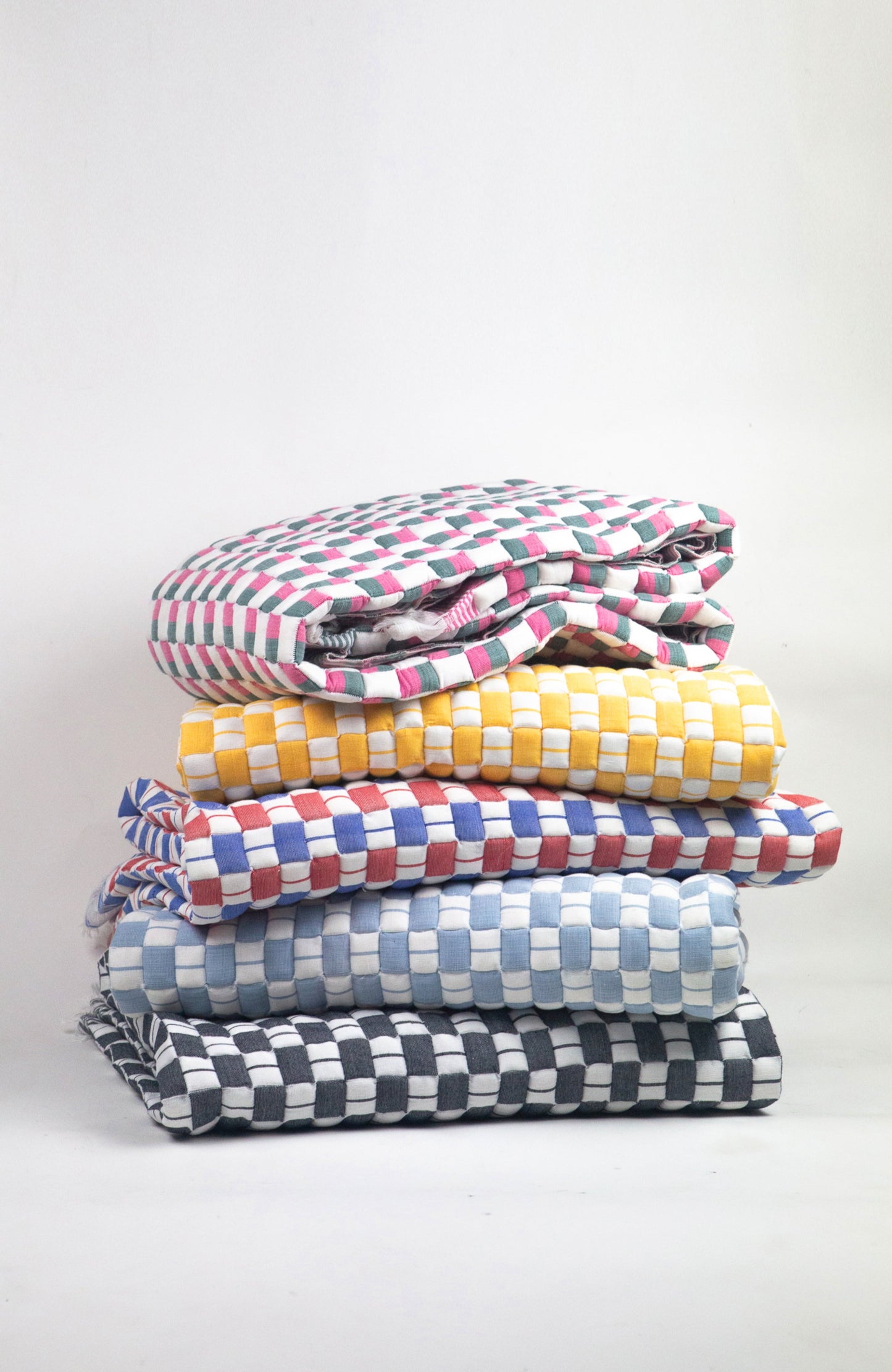Stack of colorful checkered blankets on a white background