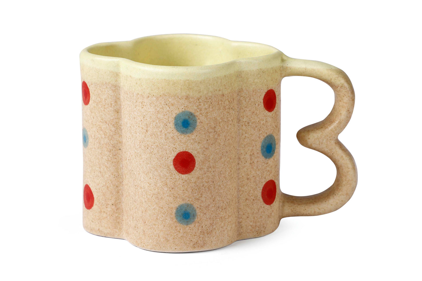 Beige mug with red and blue polka dots on a white background