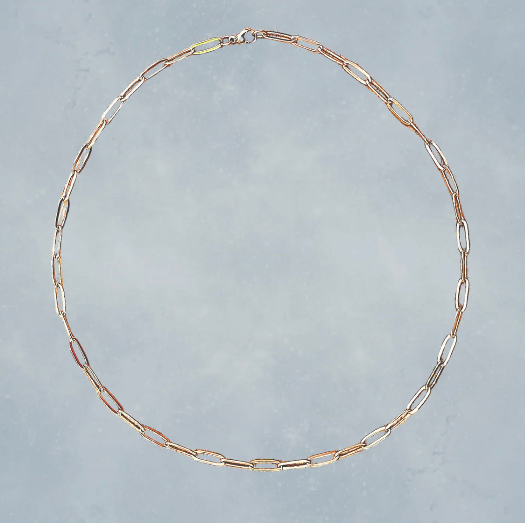 Gold chain necklace on a gray background