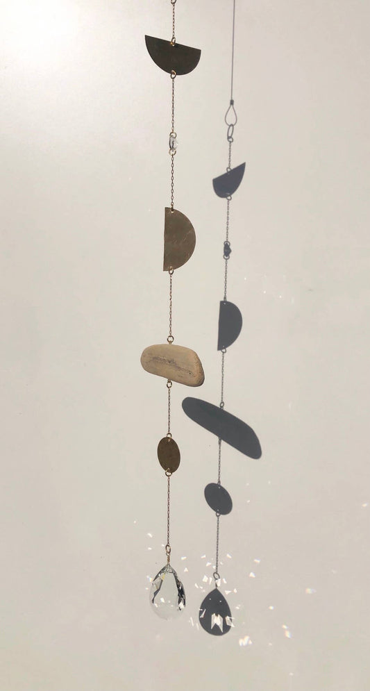Decorative hanging mobile with semi-circular shapes on a light background