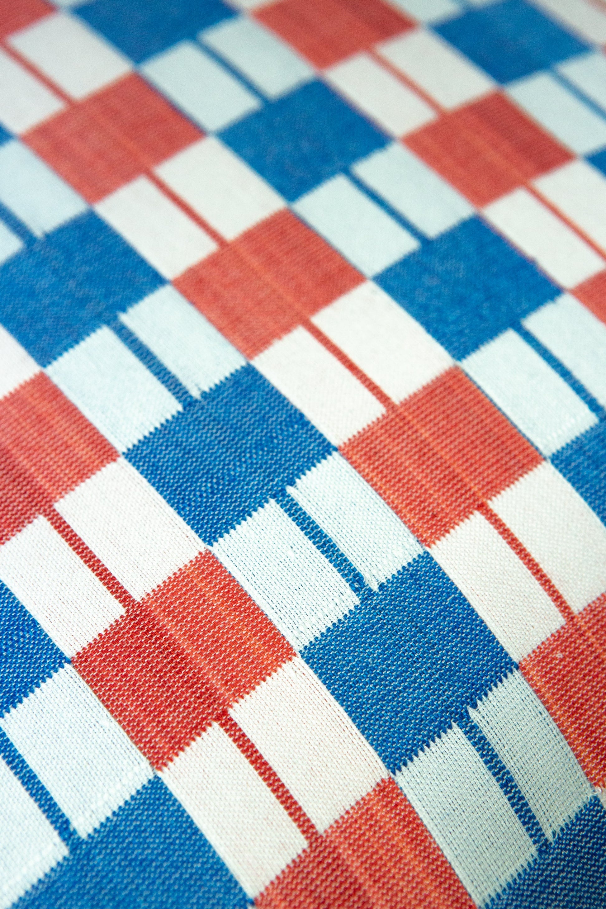 Close-up of a checkered fabric pattern with red, blue, and white squares.