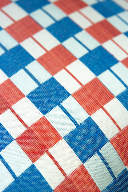 Close-up of a checkered fabric pattern with red, blue, and white squares.