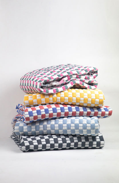 Stack of colorful checkered blankets on a white background