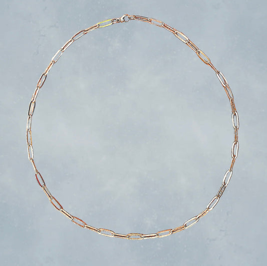 Gold chain necklace on a gray background