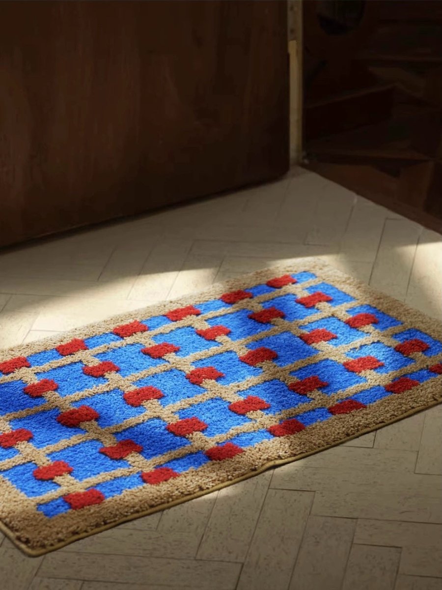 Doormat with blue, red, and beige pattern on a tiled floor